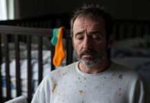 How to Handle Baby Sleep Regression Like a Pro? Frazzled parent with cold coffee in dim nursery, lopsided crib, 3:22 a.m. clock, neon sock, crumpled pamphlet.