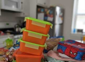 Messy kitchen counter with meal prep containers and kid's apple.